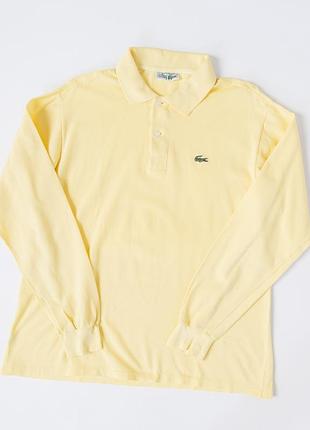Чоловіче поло lacoste світло-жовтого кольору з довгими рукавами. класична модель має комір, застібку на два ґудзики, еластичні манжети та вишитий лого