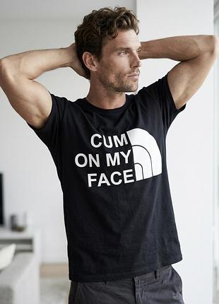Чорна чоловіча бавовняна футболка з провокаційним написом «cum on my face» і стилізованим логотипом під the north face
