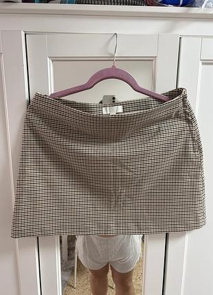 Коричнева міні-спідниця в дрібну клітинку від h&m привертає увагу своїм класичним принтом «гусяча лапка» та лаконічним прямим кроєм.