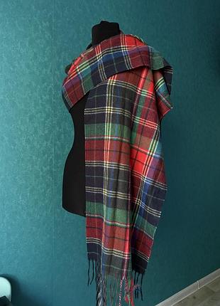 Шарф-палантин у традиційному шотландському дизайні «тартан» з яскравими червоними, зеленими та синіми клітинками та декоративними китицями.