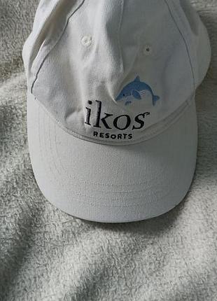 Бейсболка с вышитым синим логотипом и названием сети роскошных курортов ikos resorts