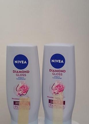 Догля-джна одżywка для волосся nivea diamond gloss brilliance об'ємом 200 мл у світло-блакитному флаконі з рожевою трояндою на етикетці.
