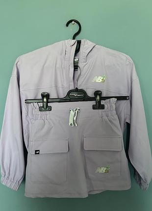 Дитячий комплект-двойка new balance (офіційна назва моделі — new balance girls skirt set / windbreaker and skorts) у ніжному лавандовому кольорі.