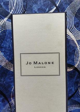 Коробка британского парфюмерного бренда jo malone london с характерной черной рамкой и тиснением логотипа