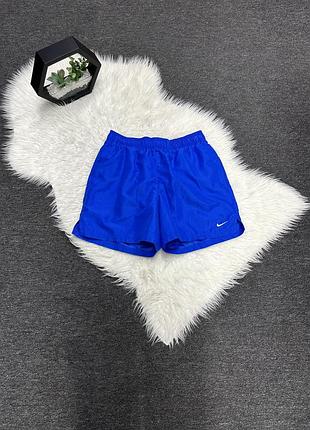 Яскраво-сині спортивні шорти nike виконані з легкого поліестеру та доповнені невеликим білим логотипом на штанині.
