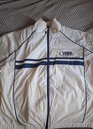 Кремовая ветровка primark sports league 1985 с контрастными темно-синими полосками и акцентным принтом на груди.