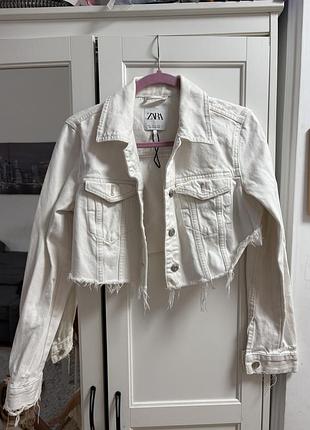 Біла вкорочена джинсова куртка від zara з необробленим, обірваним низом та потертостями.