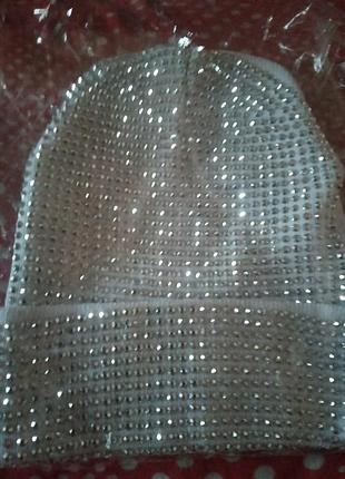 Шапочка білого кольору з металевим сяйвом на не великий розмір