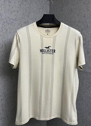 Бежева смугаста футболка від бренду hollister