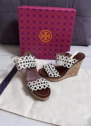 Сандалі на танкетці tory burch nori з лазерним вирізом, білими шкіряними ремінцями з вирізами та коричневими шкіряними устілками.