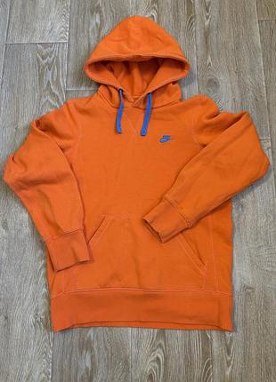 Яскраво-помаранчеве худі nike з синіми шнурками та невеликим вишитим логотипом на грудях