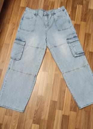 Світло-блакитні широкі джинси карго (wide-leg cargo jeans). вони мають вільний крій (baggy/relaxed fit), накладні кишені з клапанами з боків