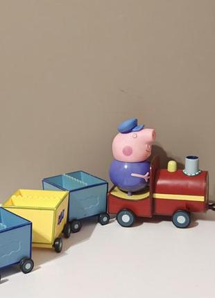 Игровой набор «паровозик дедушки пеппы» (peppa pig), в который входят красный паровоз с фигуркой машиниста и соединенные с ним разноцветные вагончики