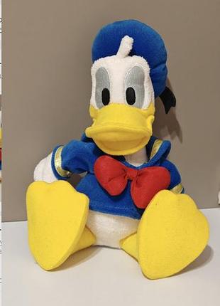 Мягкая плюшевая игрушка дональд дак (donald duck) от официального бренда disney. утенок в классическом синем костюме матроса и в  синей бескозырке.