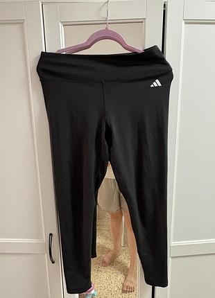 Чорні спортивні легінси adidas із високою талією та класичним білим логотипом бренда на стегні.