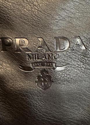М’яка чорна шкіряна сумка крос-боді prada (репліка)з тисненим логотипом і широким текстильним ремінцем з чорно-білим зигзагоподібним візерунком