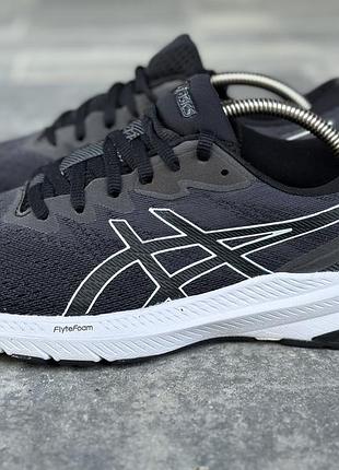 Беговые кроссовки asics gt-1000 11 в черном цвете с белой подошвой и фирменными полосками