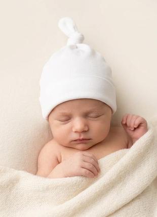 Біла трикотажна шапка з широким відворотгм та з вузликом 0-3 міс.