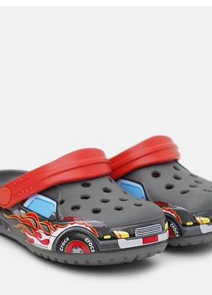 Детские сабо kids' crocs fun lab truck band clog серого цвета с красными фиксирующими ремешками и ярким принтом в виде гоночной машинки. 
розмер 6