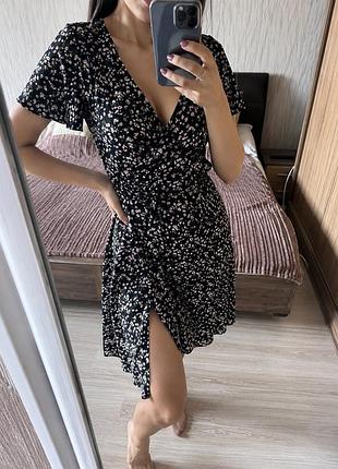 Це коротка чорна мінісукня boohoo ,на запах, з квітковим принтом та зав'язкою на талії.