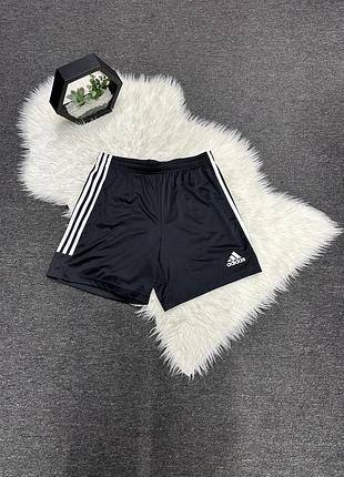 Чорні спортивні шорти adidas з білими смугами з боків та логотипом бренда на штанині.