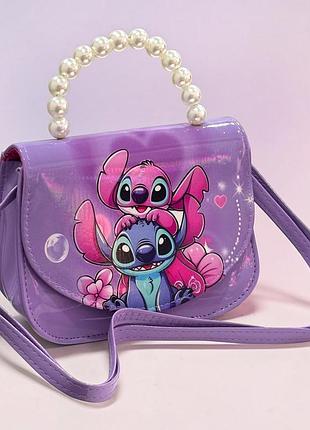 Детская сумочка стич stitch фиолетовая с жемчужной ручкой и длинным ремешком через плечо 17×12×7 см