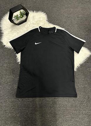 Чорну спортивну футболку nike dri-fit з білими вставками на плечах і білим логотипом-«галочкою» на грудях.