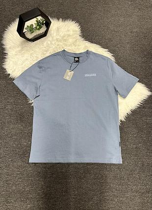 Блакитну чоловічу футболку бренду quiksilver з невеликим принтом на грудях.