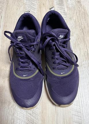 Фиолетовые кроссовки nike air max thea с белой подошвой и характерным логотипом бренда.37,5
