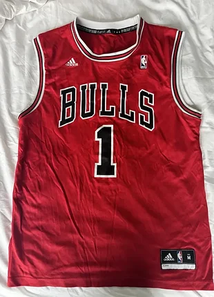 Баскетбольная джерси команды chicago bulls с номером 1, которая принадлежит легендарному разыгрывающему защитнику деррика роуза (drrick rose)