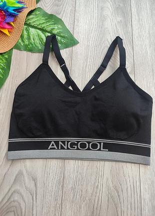 Черный бесшовный спортивный топ (бюстгальтер) бренда angool с регулируемыми бретелями и серым брендированным поясом внизу размер m