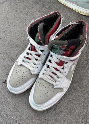 Високі кросівки air jordan 1 high zoom air cmft "hare" з білої шкіри та світло-сірої замші з червоними та різнобарвними акцентами.