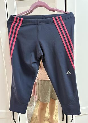 Темно-сині спортивні лосини 3/4 від adidas із яскраво-рожевими смужками з боків.