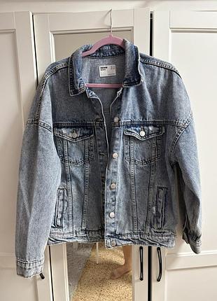 Синя джинсова куртка оверсайз крою від бренду bershka із потертостями та металевими ґудзиками