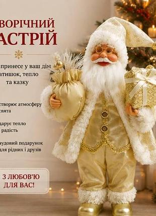 Святковий санта-клаус у золотистому костюмі, декоративна фігурка з подарунками, різдвяний декор