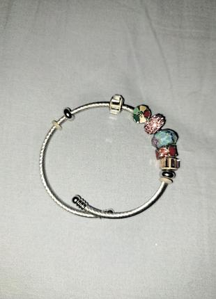 Стильний жіночий браслет у стилі pandora, виконаний зі сріблястого металу.