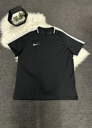 Чорна спортивна футболка nike з короткими рукавами та білими смужками на плечах.