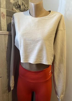 Лонгслив укороченный gymshark (модель poise long sleeve crop top / training oversized crop) в нежно-розовом/пудровом оттенке. размер s
