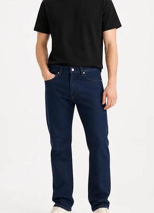 Классические темно-синие джинсы прямого кроя (предположительно, levi's 501) из плотного денима с застёжкой на пуговицах.