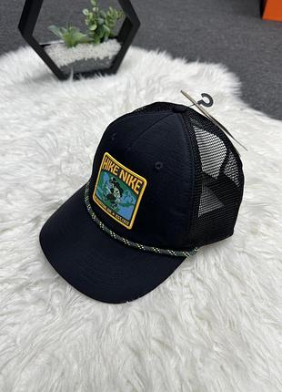 Чорну кепку-тракер nike rise structured outdoor trucker cap із патчем «hike nike» та декоративним шнурком на козирку.