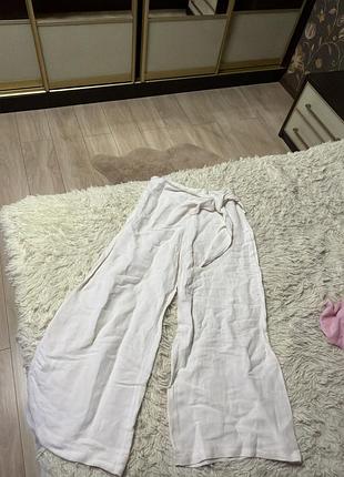 Белые женские льняные брюки свободного кроя с завязками на талии.