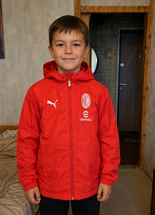 Дитяча вітровка/легка куртка puma ac milan з капюшоном, у червоному кольорі, з емблемою ac milan і логотипом puma.