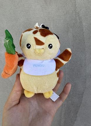 Це плюшевий персонаж колекції pudgy penguins (ймовірно, з серії plush buddies або clip-on plush) у білому ведмежому капелюсі та з морквою в лапці