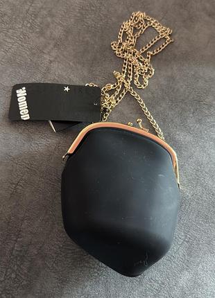 Чорна мініатюрна сумка через плече від accessorize з металевим золотистим ланцюжком та класичною застібкою-рамікою.