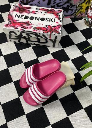 Классические шлепанцы adidas adilette яркого фуксий-розового цвета с тремя фирменными белыми полосами на ремешке