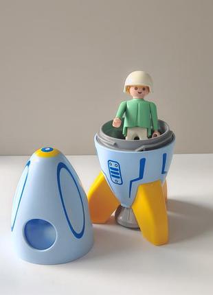 Игровой набор playmobil  космонавт с ракетой , состоящий из сине-желтой ракеты с открывающейся кабиной и фигурки