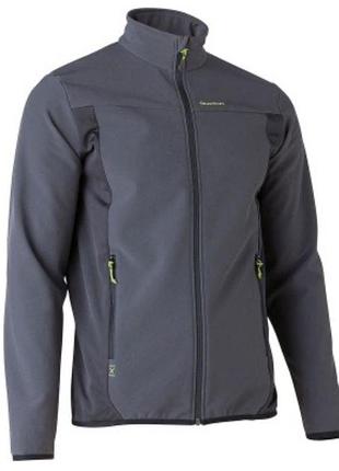 Темно-серая куртка софтшелл (softshell) бренда quechua с черными боковыми вставками и яркими салатовыми деталями на воротнике и карманах.