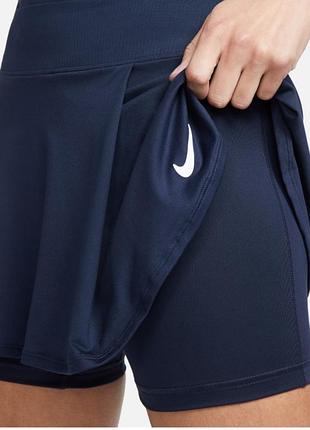 Темно-синяя спортивная юбка-шорты nike с узнаваемым белым логотипом на подоле.