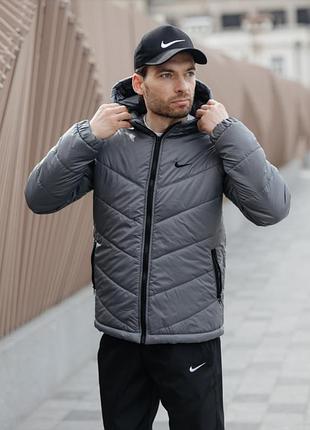 Молодіжна утеплена чоловіча куртка nike сіра з прямим кроєм, реглановими рукавами, регульованим низом і кишенями для речей