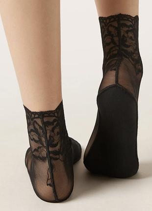 Жіночі шкарпетки calzedonia з тюлю та мережива чорного кольору з вишуканим квітковим візерунком.